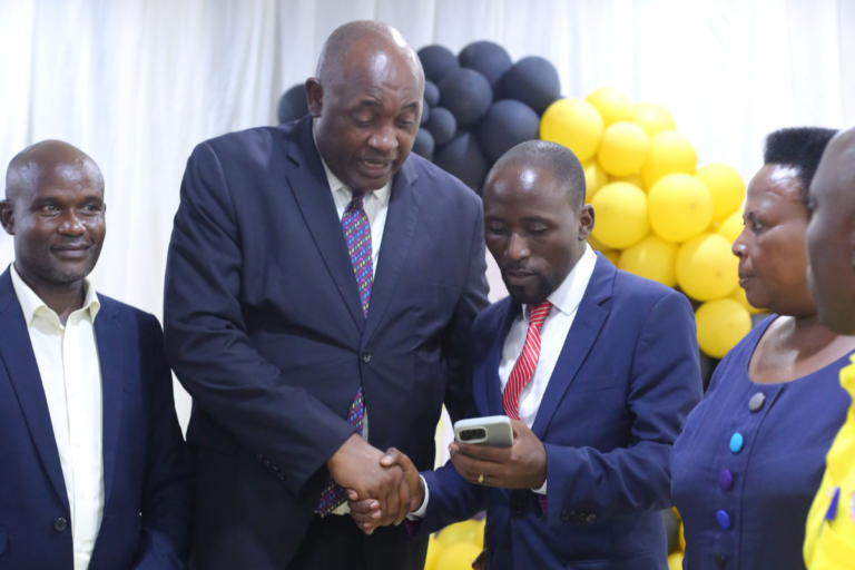 Honourable-Baryomunsi-shaking-hands-with-Ashaba-Vincent
